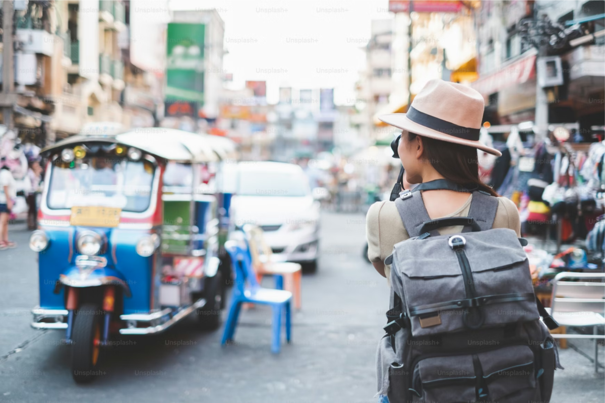 Solo traveler with a backpack walking through a busy city street.